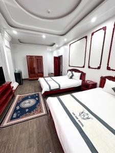 a hotel room with two beds and a tv at Cao Ánh Hotel in Minh Hóa +2 photos