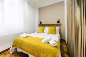 a bedroom with a bed with yellow blanket and yellow pillows at Terraza, 20min playas, 5min Pontevedra, Garaje in Pontevedra
