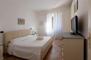 a bedroom with a bed and a flat screen tv at Hotiday Villa Porto Rotondo in Porto Rotondo +44 photos
