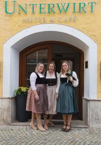 three women standing in front of a hotel building at Unterwirt in Waging am See