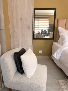 a living room with a chair and a mirror at Ring Road Guesthouse in Vereeniging