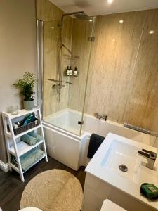 a bathroom with a shower and a tub and a sink at The Ferry Loft Montrose in Montrose +11 photos