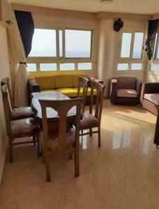 a living room with a table and chairs and a couch at Ibiza beach apartments in Alexandria