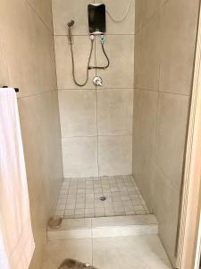 a bathroom with a shower with a tiled shower at Ring Road Guesthouse in Vereeniging