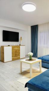 a living room with a tv and a coffee table at KM Art Apartman in Sfântu-Gheorghe +28 photos