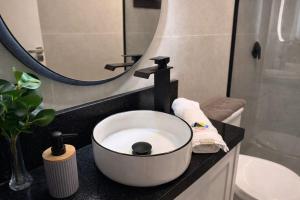 a bathroom with a bowl sink and a mirror at Cabana Escandinávia Praia de Fora in Palhoça