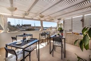a patio with tables and chairs on a balcony at Dea's Rooms in Noto