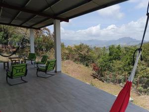 a porch with chairs and a hammock and a view at Boca de viento Chica in Chicá