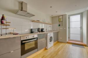 a kitchen with a washing machine and a washer at La maisonnette - 4 pers - Centre ville - télétravail in Angoulême +3 photos