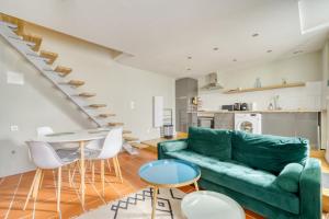 a living room with a green couch and a table at La maisonnette - 4 pers - Centre ville - télétravail in Angoulême