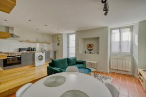 a living room with a white table and a green couch at La maisonnette - 4 pers - Centre ville - télétravail in Angoulême