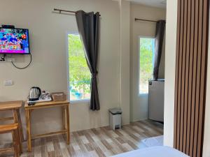 a room with a desk and a television on a wall at Sukhothai Indy Resort in Sukhothai