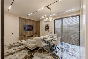 a dining room with a table and chairs and a tv at Renest Florence Art Escape in Chişinău