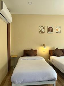 a bedroom with two beds in a room at Sukhothai Indy Resort in Sukhothai