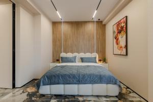 a bedroom with a large bed with blue pillows at Renest Florence Art Escape in Chişinău