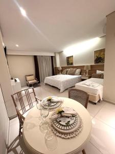 a room with a table with chairs and a bedroom at Rodoserv Hotel in Pardinho