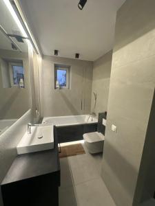 a bathroom with a sink and a tub and a toilet at Apartament rodzinny in Łańcut