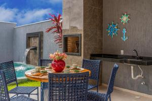 a patio with a table and chairs and a pool at Renner Ventos praia do Preá Casa Completa com Piscina in Cruz