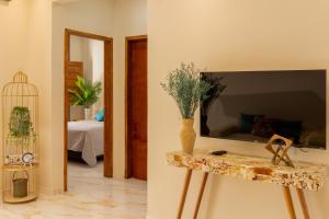 a room with a table with a tv on a wall at Renner Ventos praia do Preá Casa Completa com Piscina in Cruz