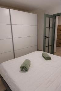 a white bed with two pillows on top of it at Apartman Kelečić in Gornji Stupnik