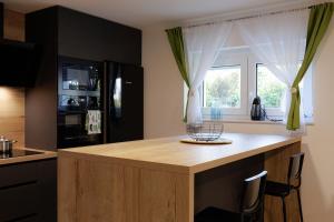 a kitchen with a counter with chairs and a window at Apartman Kelečić in Gornji Stupnik