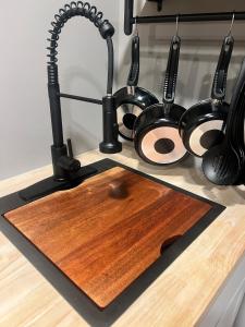 a kitchen counter with a wooden cutting board and utensils at Romantic Riverfront Retreat in Sugar Run +29 photos