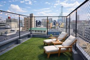 a balcony with two chairs and a table on a roof at 心斎橋難波関空直通Kumano Sanctum Ambers Hostel in Osaka