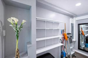 ein Zimmer mit weißen Regalen und einer Vase mit Blumen in der Unterkunft Stylish and Pet-Friendly Apartment in Beacon in Beacon