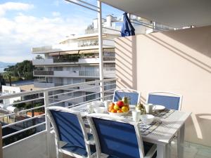 a balcony with a table and chairs with a bowl of fruit at SOPHIES HOMES FÉLIBRIGES BEACH & PALAIS des FESTIVALS in Cannes
