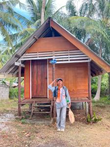 a man standing in front of a small house at บากันใหญ่โฮมสเตย์ in Ban Ba Kan Yai