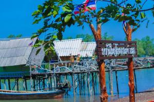 a bench sitting next to a dock with a boat at บากันใหญ่โฮมสเตย์ in Ban Ba Kan Yai