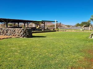 a park with a bench and a stone wall at Betta Lodge in Duwisib