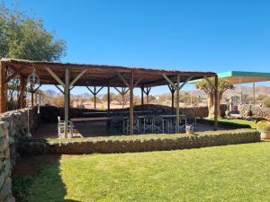 a pavilion with a picnic table in a park at Betta Lodge in Duwisib