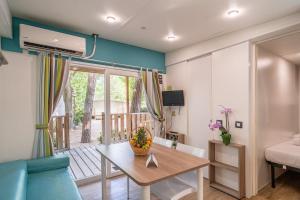 a living room with a table and a balcony at Club del Sole Adriano Family Collection in Punta Marina