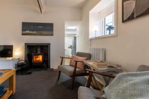 a living room with a fireplace and a table and chairs at Ty Capel Bach in Bodorgan