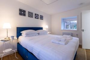 a bedroom with a large bed with white sheets and pillows at Ty Capel Bach in Bodorgan
