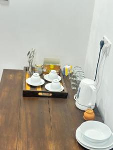 a wooden table with white plates and cups on it at Brown Birds Villa in Tangalle