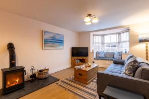 a living room with a couch and a fireplace at Kite Cottage in Llangadwaladr