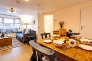 a kitchen and living room with a wooden table at Kite Cottage in Llangadwaladr +19 photos