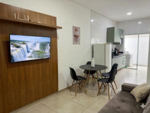a living room with a table and a tv on a wall at 3 Frontiers Landmark House in Foz do Iguaçu +13 photos