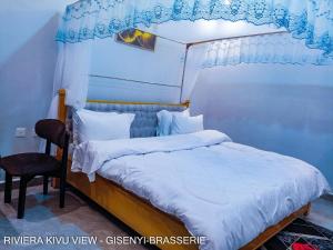 a bedroom with a canopy bed and a chair at Riviera Kivu View in Gisenyi