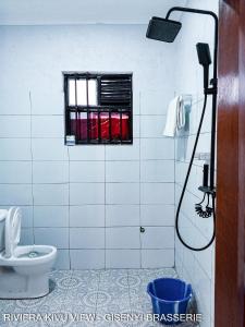 a bathroom with a toilet and a window at Riviera Kivu View in Gisenyi +18 photos