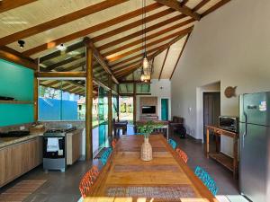 a kitchen with a long wooden table in a room at Brisas de Bonito: ótima casa, condomínio, 2 suítes in Bonito