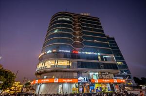 a tall building with people standing in front of it at Rooms To Go - Indian Guest only in Vadodara