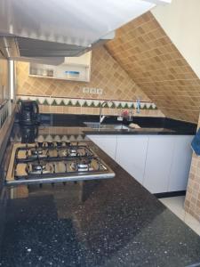 a kitchen with a stove top oven in a kitchen at Appartement Imi-Ouaddar 1 in Agadir nʼ Aït Sa +6 photos