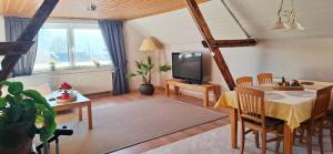 a living room with a dining table and a television at Ferienwohnung "Zum Schlossblick" in Mansfeld