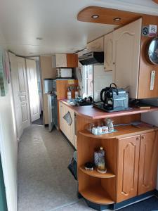 a kitchen in an rv with a sink and a counter at Mobil home Cristal in Biville-sur-Mer