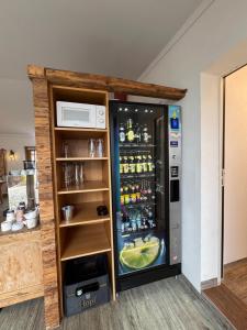 a refrigerator filled with lots of alcohol in a room at Pension Schweizerhaus Garni in Weyarn