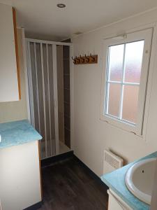a bathroom with a sink and a window at Mobil home Cristal in Biville-sur-Mer