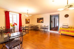 a living room with tables and chairs in it at Hôtel Jean XXII in Cahors